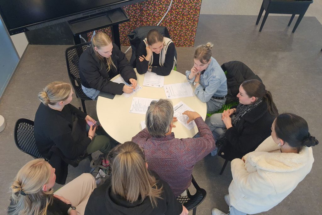 Studenten en docent aan tafel